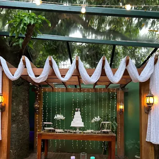 Cenário de casamento com bolo, luzes e tecido branco