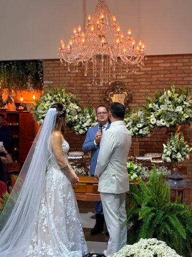 Noiva e noivo durante uma cerimônia decorada com flores brancas