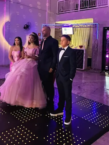 Debutante de vestido rosa ao lado da família em sua festa