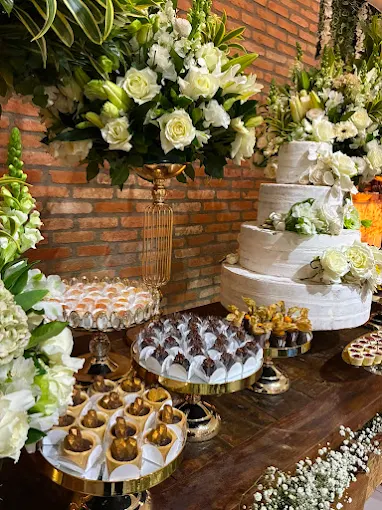 Bolo de casamento e mesa de doces decorada com flores brancas