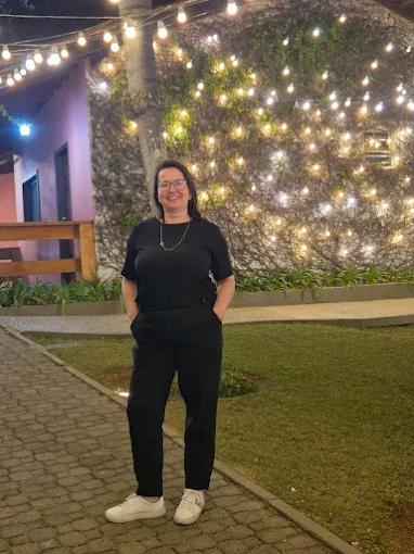 Gleice, assessora e cerimonialista, em ambiente externo iluminado